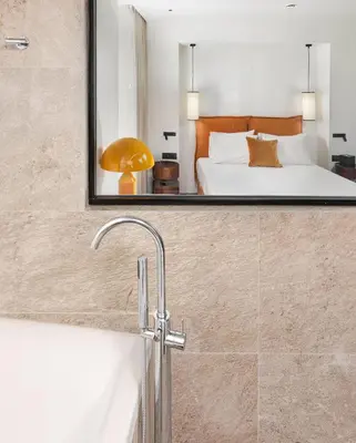 a bathroom with a bath tub and a bedroom at The Residence Aiolou Hotel & Spa in Athens