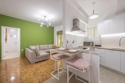 a kitchen and living room with a table and a couch at Stylish Luxury Apartment at Ampelokipi Metro station in Athens