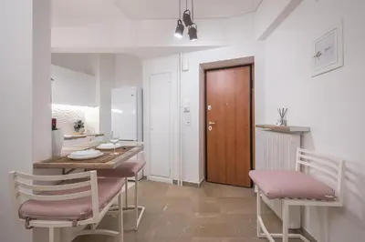 a room with a table and chairs and a kitchen at Stylish Luxury Apartment at Ampelokipi Metro station in Athens