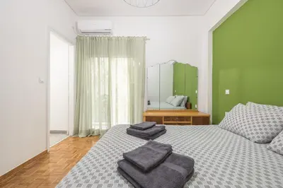a bedroom with a bed with three towels on it at Stylish Luxury Apartment at Ampelokipi Metro station in Athens