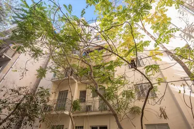 a large white building with a balcony and trees at Stylish Luxury Apartment at Ampelokipi Metro station in Athens