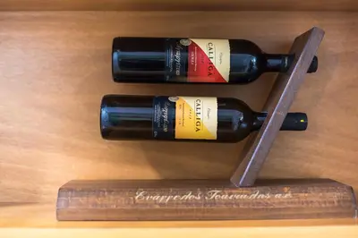 three wine bottles on a wooden rack on a table at Stylish Luxury Apartment at Ampelokipi Metro station in Athens
