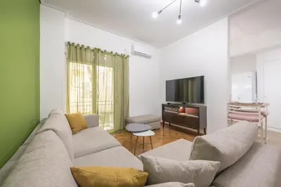 a living room with a couch and a tv at Stylish Luxury Apartment at Ampelokipi Metro station in Athens
