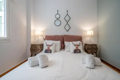 a bedroom with a large white bed with two lamps at Athens Gift, only 300m from Acropolis Museum in Athens