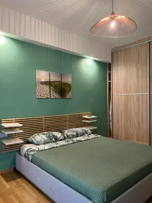 a bedroom with a bed with a green wall at 1 BedRoom Apt - Live Like A Local In Kolonaki in Athens