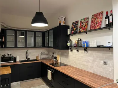 a kitchen with black cabinets and wooden counter tops at 1 BedRoom Apt - Live Like A Local In Kolonaki in Athens