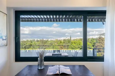 a window in a room with a table and a view at Hestia - Alexandras 38 in Athens