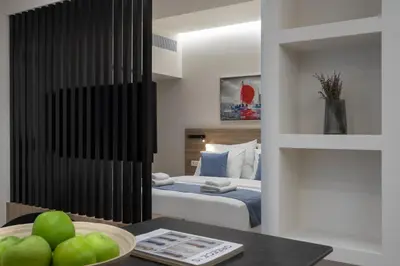 a bedroom with a bed and a table with a bowl of apples at Hestia - Alexandras 38 in Athens
