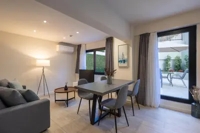 a living room with a table and chairs and a couch at Hestia - Alexandras 38 in Athens