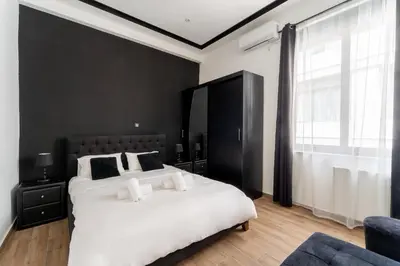 a bedroom with a large white bed and a window at Neo Luxury Suite in Athens