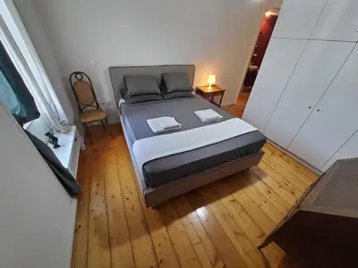 a large bed in a room with a wooden floor at AcroView in Athens