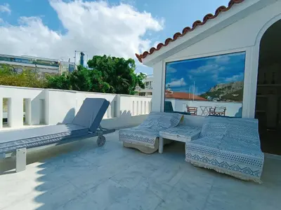 a balcony with two chairs and a table on a roof at AcroView in Athens