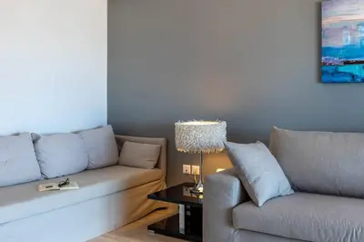 a living room with a couch and a table at Four Seasons Sea View Apartment in Athens