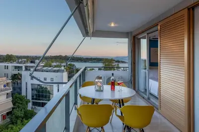 a balcony with a table and chairs and a view at Four Seasons Sea View Apartment in Athens
