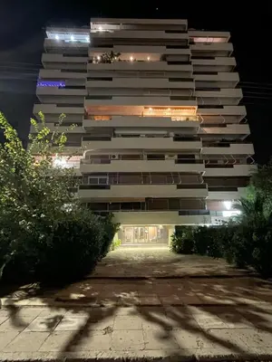 a tall building at night with its lights on at Four Seasons Sea View Apartment in Athens