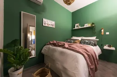 a green bedroom with a bed and a mirror at The Boutique in Athens
