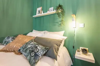 a bedroom with a green wall and a bed with pillows at The Boutique in Athens