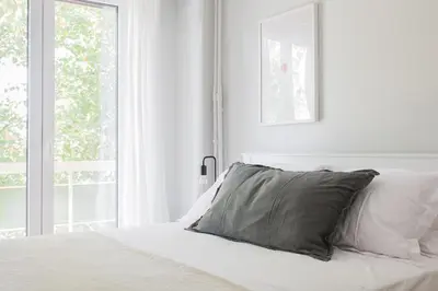 a white bedroom with a bed with a pillow on it at Absolute 2BR Apartment near EMST Museum by UPSTREET in Athens