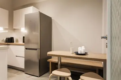 a kitchen with a stainless steel refrigerator and a table at Absolute 2BR Apartment near EMST Museum by UPSTREET in Athens