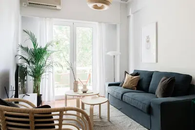 a living room with a blue couch and a table at Absolute 2BR Apartment near EMST Museum by UPSTREET in Athens