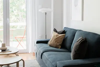 a blue couch with pillows in a living room at Absolute 2BR Apartment near EMST Museum by UPSTREET in Athens