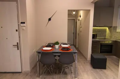 a kitchen with a table with chairs and a clock on the wall at Luxury apartment 10’ from the center! in Athens