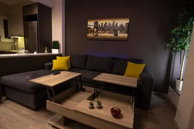 a living room with a blue couch and yellow pillows at Luxury apartment 10’ from the center! in Athens