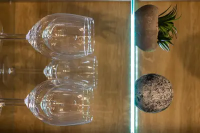 a couple of glasses on a table with a vase at Luxury apartment 10’ from the center! in Athens