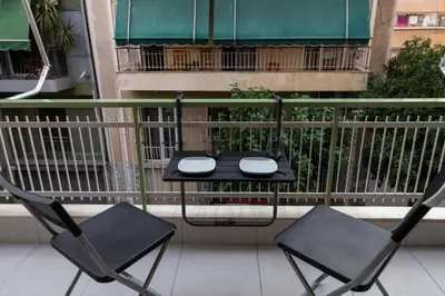 a table and two chairs on a balcony at Luxury apartment 10’ from the center! in Athens