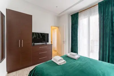 a bedroom with a green bed with two towels on it at Acropolis Royal Suite in Athens