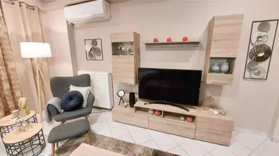 a living room with a television and a chair at Unique, Stylish Studio near Beaches in Athens