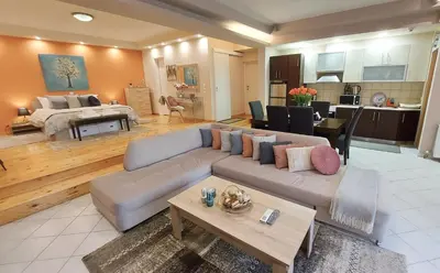 a large living room with a couch and a table at Unique, Stylish Studio near Beaches in Athens