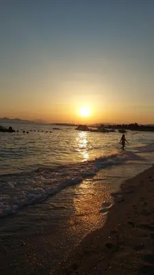 a person walking on the beach at sunset at Unique, Stylish Studio near Beaches in Athens