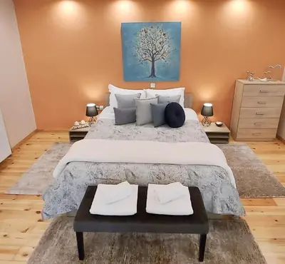a bedroom with a large bed with a blue painting on the wall at Unique, Stylish Studio near Beaches in Athens