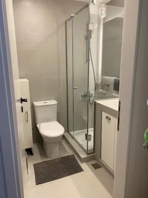 a bathroom with a toilet and a glass shower at Bright, Cosy Studio close to Glyfada Beach & Center in Athens