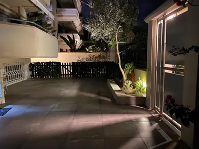 a patio lit up at night with a tree on it at Bright, Cosy Studio close to Glyfada Beach & Center in Athens