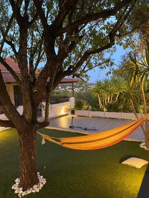 a hammock hanging from a tree in a yard at La casa de PortoRafti in Porto Rafti