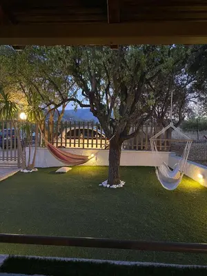 two hammocks in a yard with a tree at La casa de PortoRafti in Porto Rafti