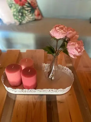 a vase with a flower and four candles on a table at La casa de PortoRafti in Porto Rafti