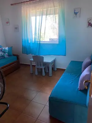 a room with a bed and a table and a window at La casa de PortoRafti in Porto Rafti