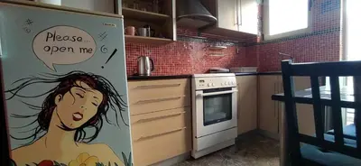 a kitchen with a refrigerator with a woman painted on it at Experience the sweetest nest at Marina Zea in Piraeus