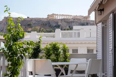 a balcony with a table and chairs and a view of the city at ERMOU STREET APARTMENTs in Athens