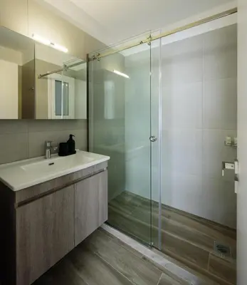 a bathroom with a sink and a glass shower at ERMOU STREET APARTMENTs in Athens