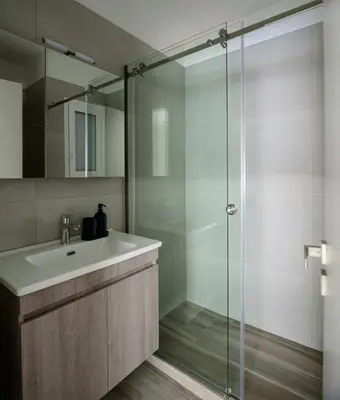 a bathroom with a sink and a glass shower at ERMOU STREET APARTMENTs in Athens