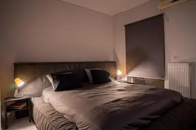 a bedroom with a large bed with a large window at It is a pleasant, modern, functional house! in Piraeus