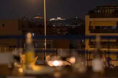 a view of a city at night with lights at It is a pleasant, modern, functional house! in Piraeus