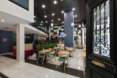 a restaurant with tables and chairs in a building at Trendy Hotel by Athens Prime Hotels in Athens
