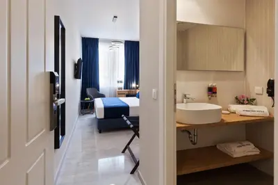 a bathroom with a bed and a sink in a room at Trendy Hotel by Athens Prime Hotels in Athens