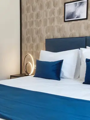 a blue and white bed with blue pillows on it at Trendy Hotel by Athens Prime Hotels in Athens
