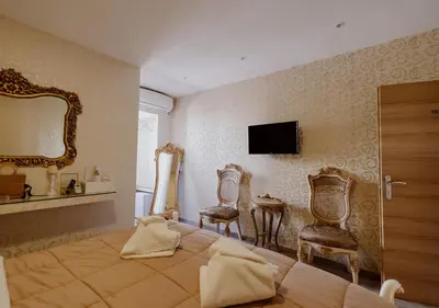 a bedroom with a bed and two chairs and a mirror at ROH Suites in Athens